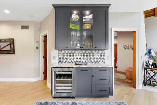 Beverage station and wine fridge located at the junction of the front office, guest bath, mud room, and family room.