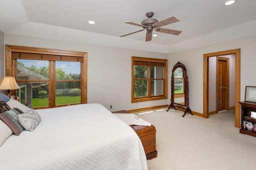 The expansive primary suite offers a serene retreat, featuring dual walk-in closets for effortless organization. Large windows frame picturesque views of the lush, tree-lined backyard, bringing tranquility and privacy to your everyday routine.