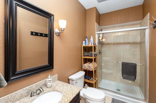 This beautifully updated 3/4 bathroom in the lower level showcases granite and refined tilework, creating a space that feels both stylish and functional.