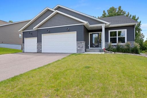 Gorgeous, 2022 rambler built by Fieldstone Builders located on a fenced lot . The home features a maintenance free exterior with stone accent and vinyl shakes, an inviting covered entry with recessed lighting and beautiful boulder retaining wall.