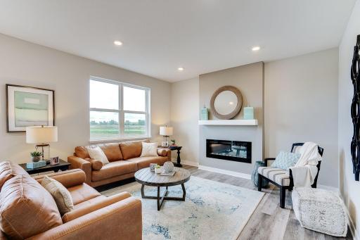 Accent feature of the living room is the electric fireplace which can change color with the season. *Picture is of model home; finishes in actual home may vary.