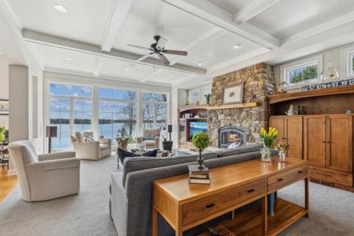 Gorgeous Living Room with long lake views, coffered ceilings, and stone fireplace.
