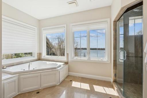 Deluxe Primary Bath with heated tile floors, soaking tub, and of course, stunning lake views.