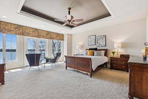 Spectacular Primary Suite with walls of glass overlooking the lake. The pan vaulted ceiling and ceiling fan create a beautiful airy suite.