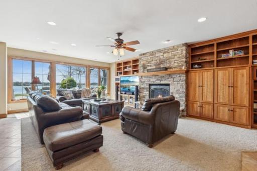 Lower Level Family Room boasts great lake views, a ceiling fan and stone fireplace. Perfect for movie night