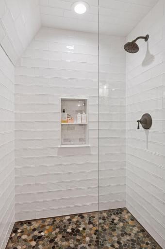 Pebble rock flooring in lower level bathroom