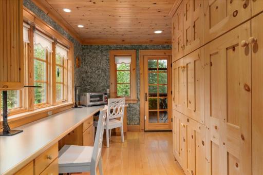 The pantry space is right behind the kitchen offering floor to ceiling cabinetry and office space overlooking the front yard.