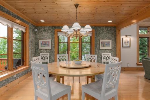 Stunning slatted wood ceiling flanked by oversized windows makes this dining area a true masterpiece for dinners.