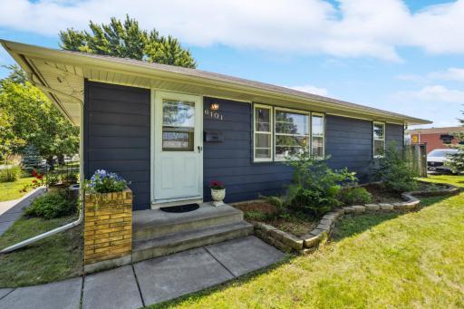 Arrive at the front door with concrete steps and a concrete sidewalk in great condition with a lovely planter for a seasonal displays of flowers or greenery