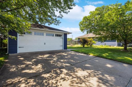 Large 2 car garage with a newer garage door and a concrete driveway