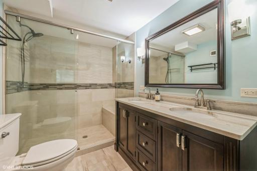 Recently updated lower level bath features large shower, raised vanity with double sinks and heated floors.