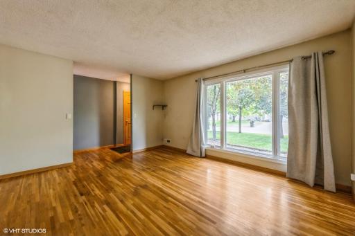 The living room features an extra large picture window and hardwood floors.