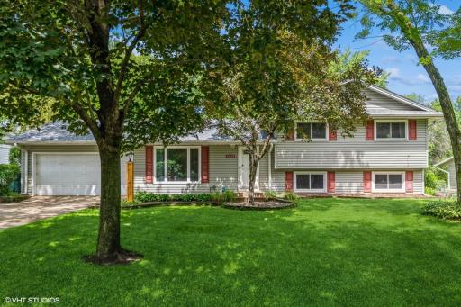 Inviting home with mature trees, maintenance free exterior, in-ground sprinkler system and concrete driveway.