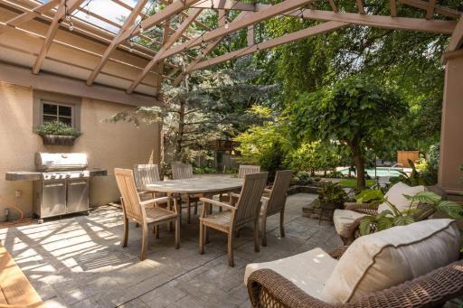 Right out you back door, a charming patio sits under a pergola.