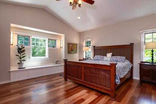 The huge primary suite has vaulted ceilings and custom details like the built-in window seat.