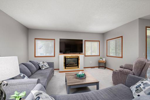 Great living space here with the windows for sunny natural light and also a cozy gas fireplace.