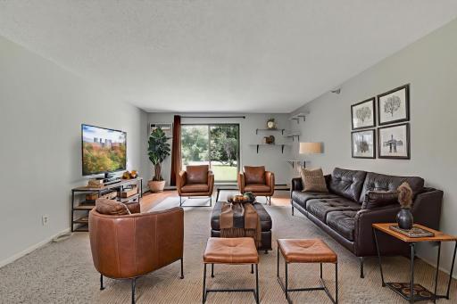 Spacious Living Room and access to the patio and nature views out the sliding glass door. The photo has been virtually staged to show you the size of the room.