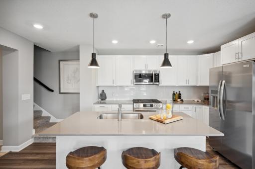 (Photo of decorated model, actual home's finishes vary) Welcome to your new home! This spacious kitchen features a large center island with quartz countertops, under mount sink, recessed lighting, LVP hardwood floors, stainless appliances and more!