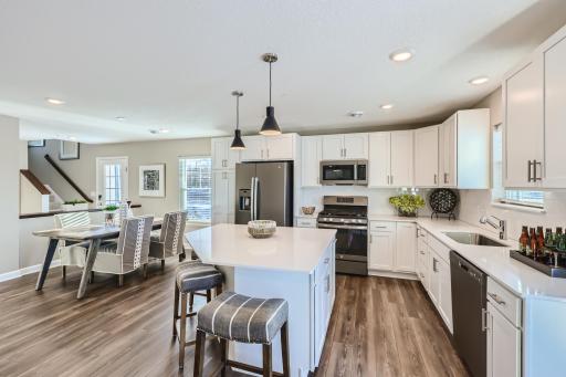 (Photo of a decorated model, actual homes finishes will vary) The open design overlooks the dining area in a simplified layout.