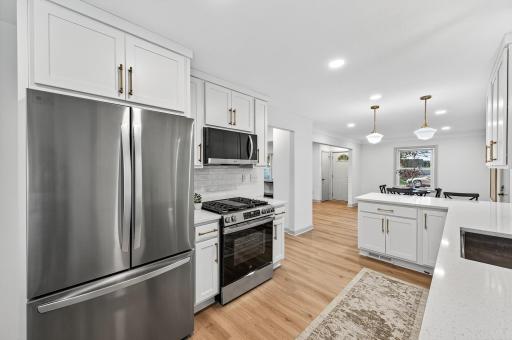 he kitchen is brand new and fully loaded with quartz countertops, stainless steel appliances, a gas range, and generous peninsula that opens to a sunlit dining room and walk out deck, perfect for entertaining.