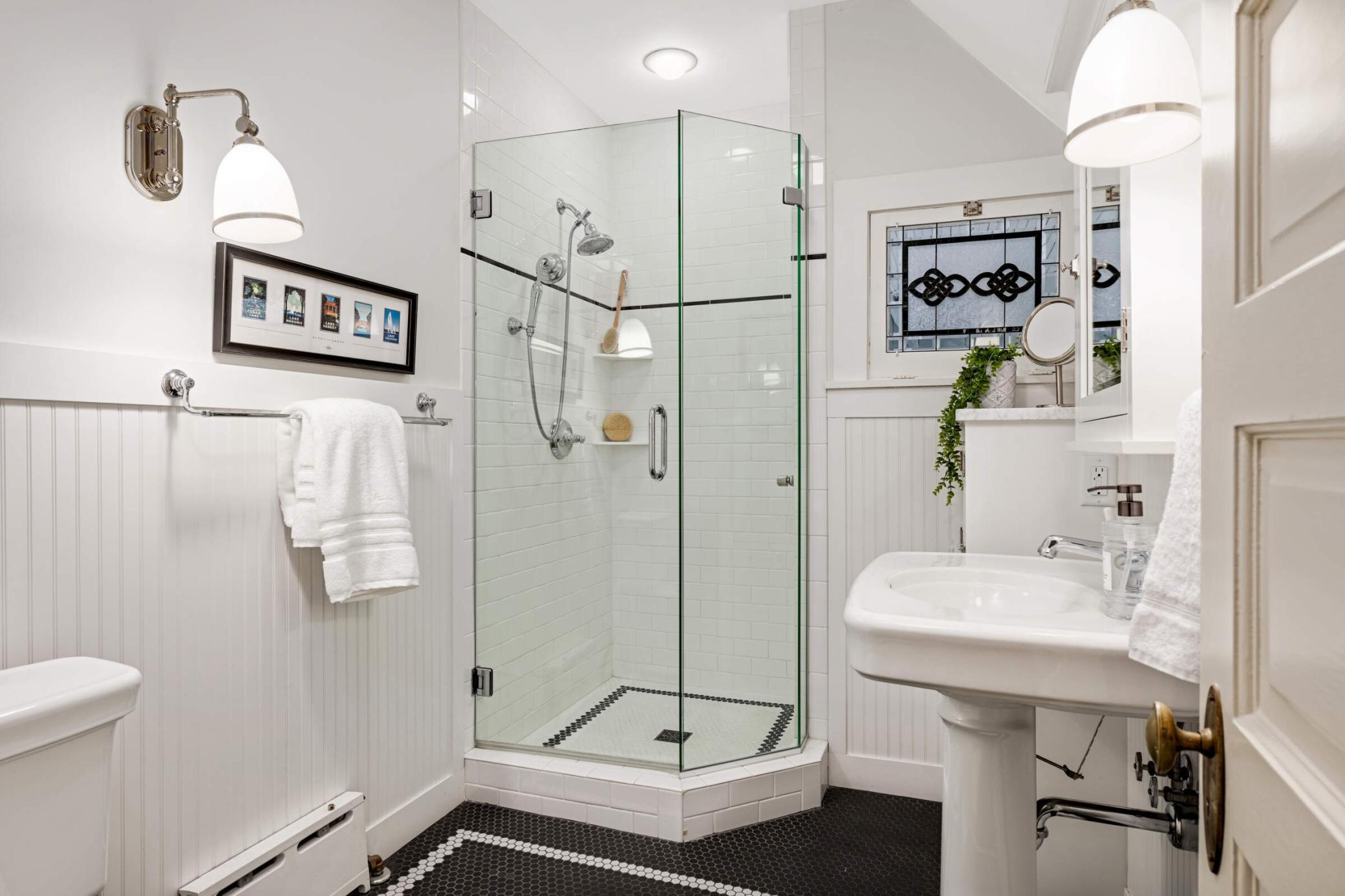 Charming white & black tiled 3/4 bathroom on the 3rd floor.