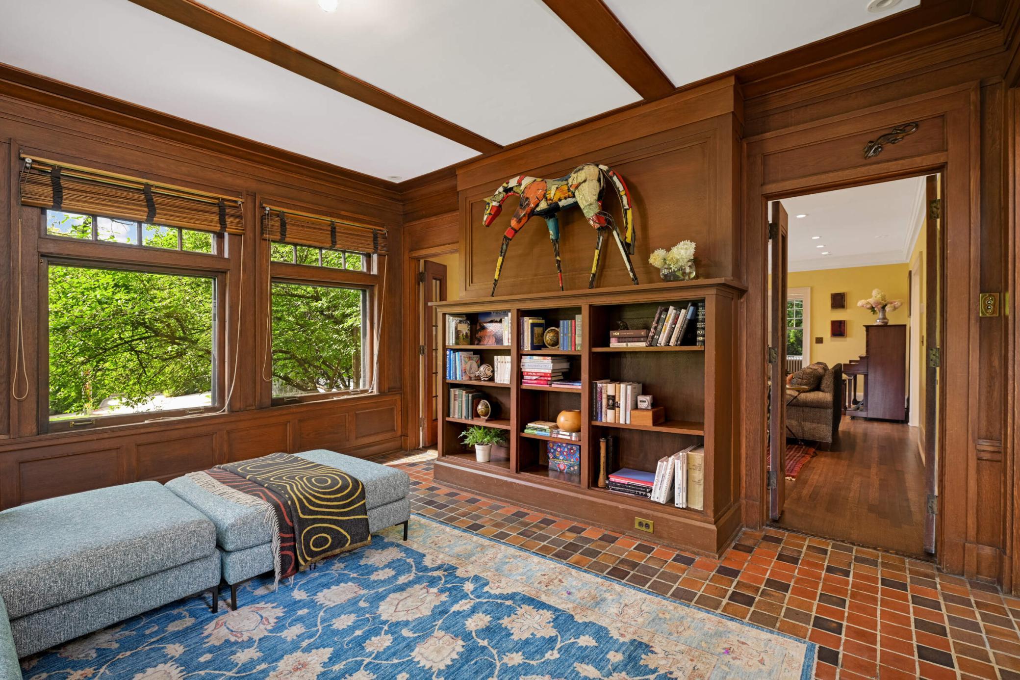 French doors from the living room lead to the cozy wood-paneled den.