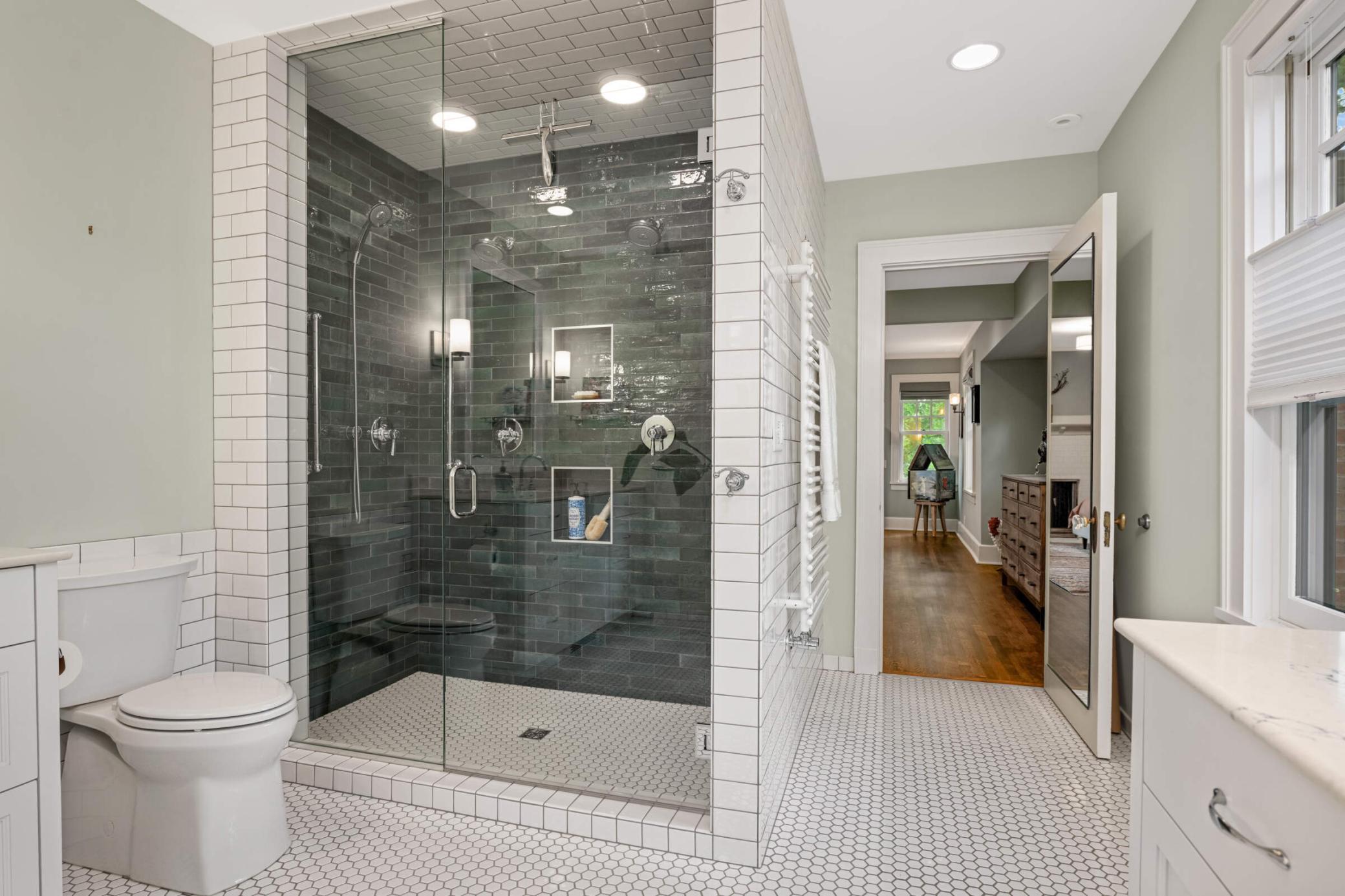 The primary bath has luxe floor-to-ceiling tilework.
