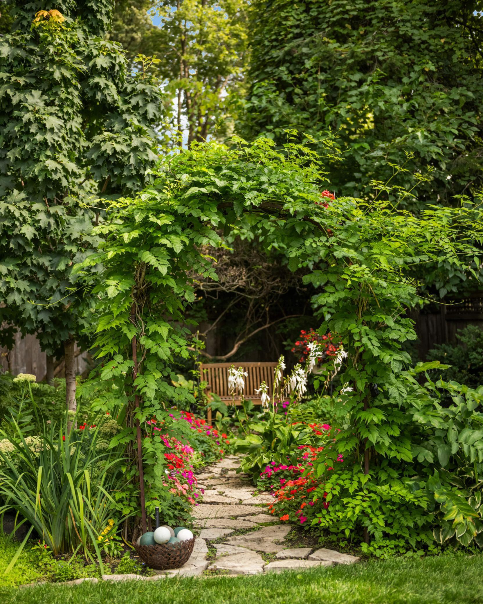 The backyard is a true oasis with multiple hang-out areas and pathways along the gardens.