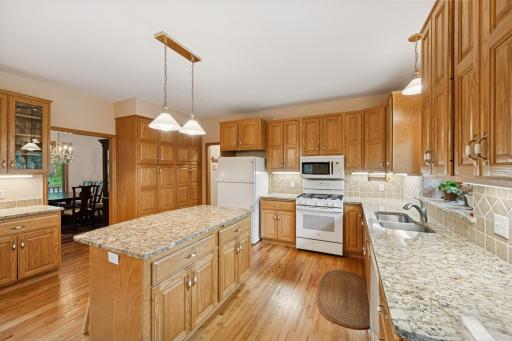 See the kitchen details with the granite counters, built in hutch, a full wall pantry and tile backsplash.