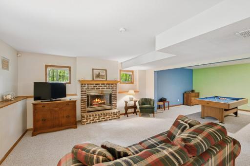 Lower level family room offers the second wood burning fireplace. Brick accents the hearth with a solid wood carved mantle. Transom windows offer additional light.