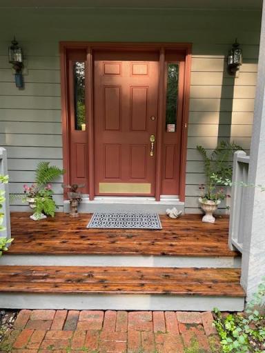 Step inside. The cozy entry sets the tone, highlighting the rich woods and tasteful finishes you will see. The owner has pressure washed the deck flooring for a wood vs painted finish previously shown. Notice the detail of the Paver sidewalk.