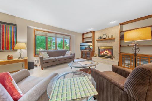 Step inside to an inviting open-concept layout where the kitchen flows seamlessly into the dining and living areas, anchored by a cozy gas fireplace.