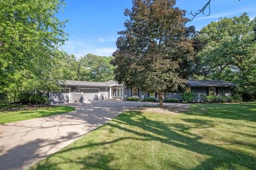 Front view of the home with long private driveway and additional guest parking.