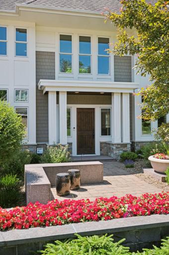 A charming stone pathway, with planters, leads you to a welcoming entrance.