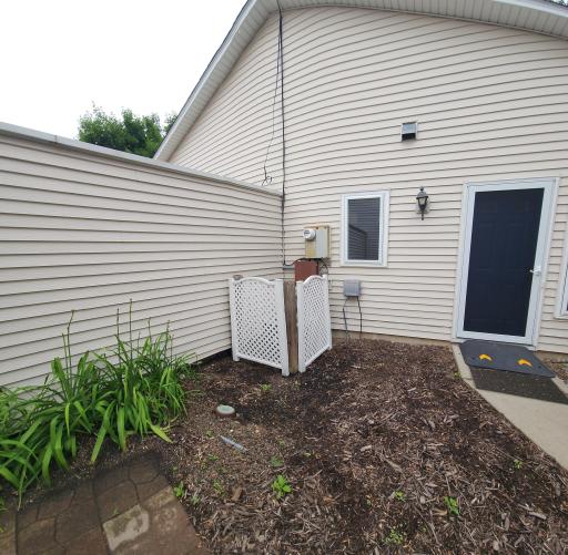 Patio area between garage and home. Nicely kept!