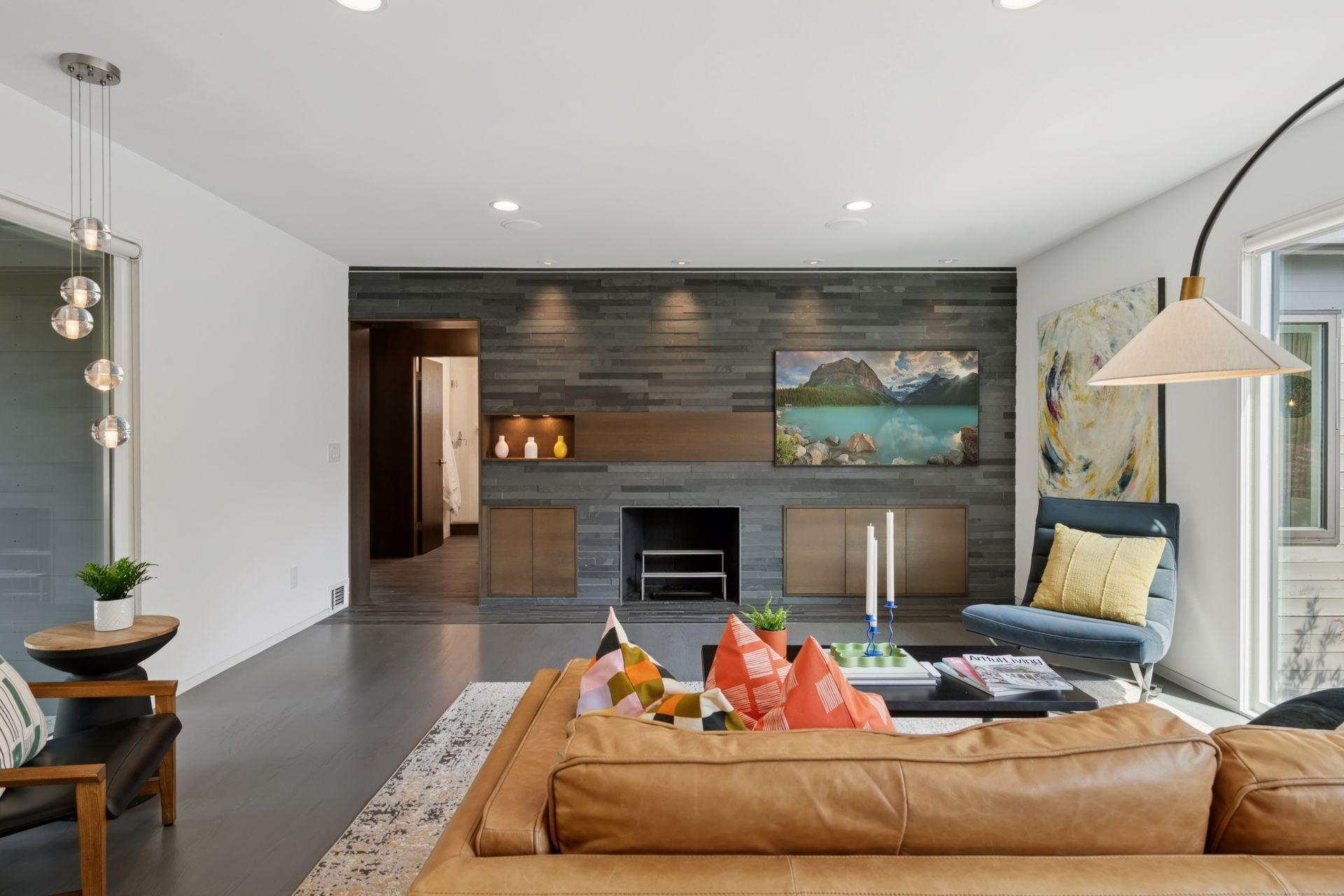 Main level living room with wood burning fireplace and slate tile wall and Frame TV