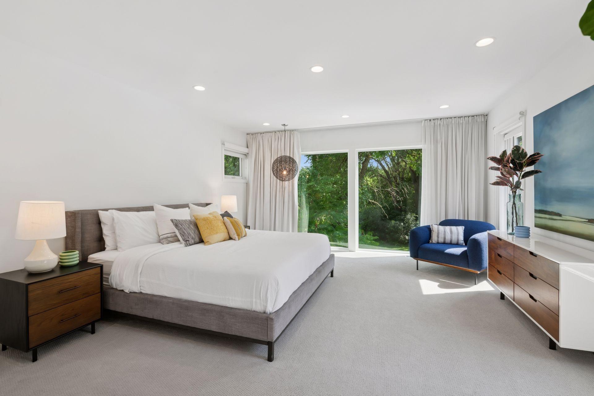 Primary suite with large glass facing Minnehaha Creek and the pool