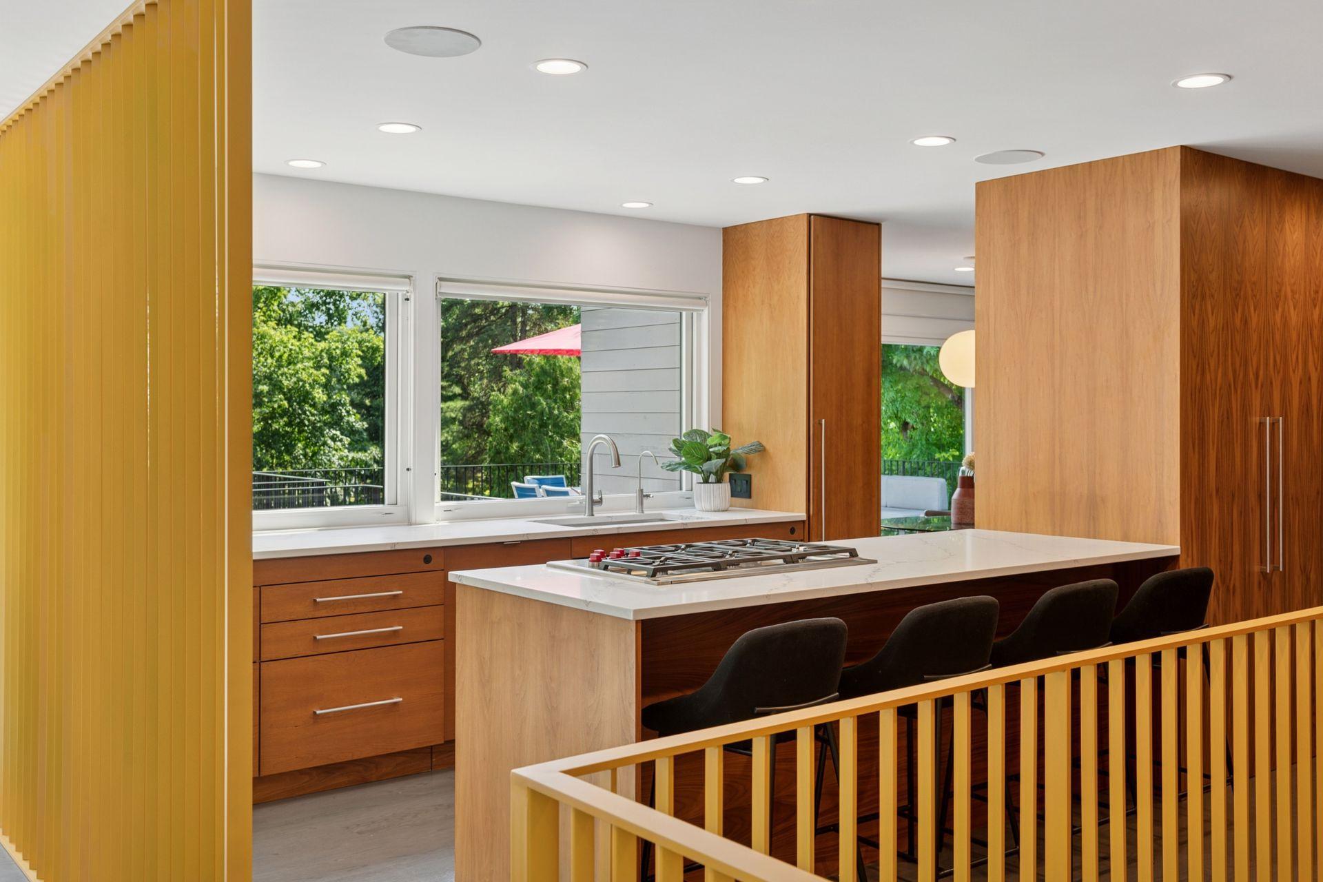 Gorgeous remodeled kitchen with new Wolf Cooktop, quartz countertops, new railings, & large glass facing the creek.