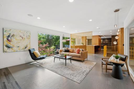 Open floor plan with living room, kitchen, and dining room featuring mid-century modern finishes