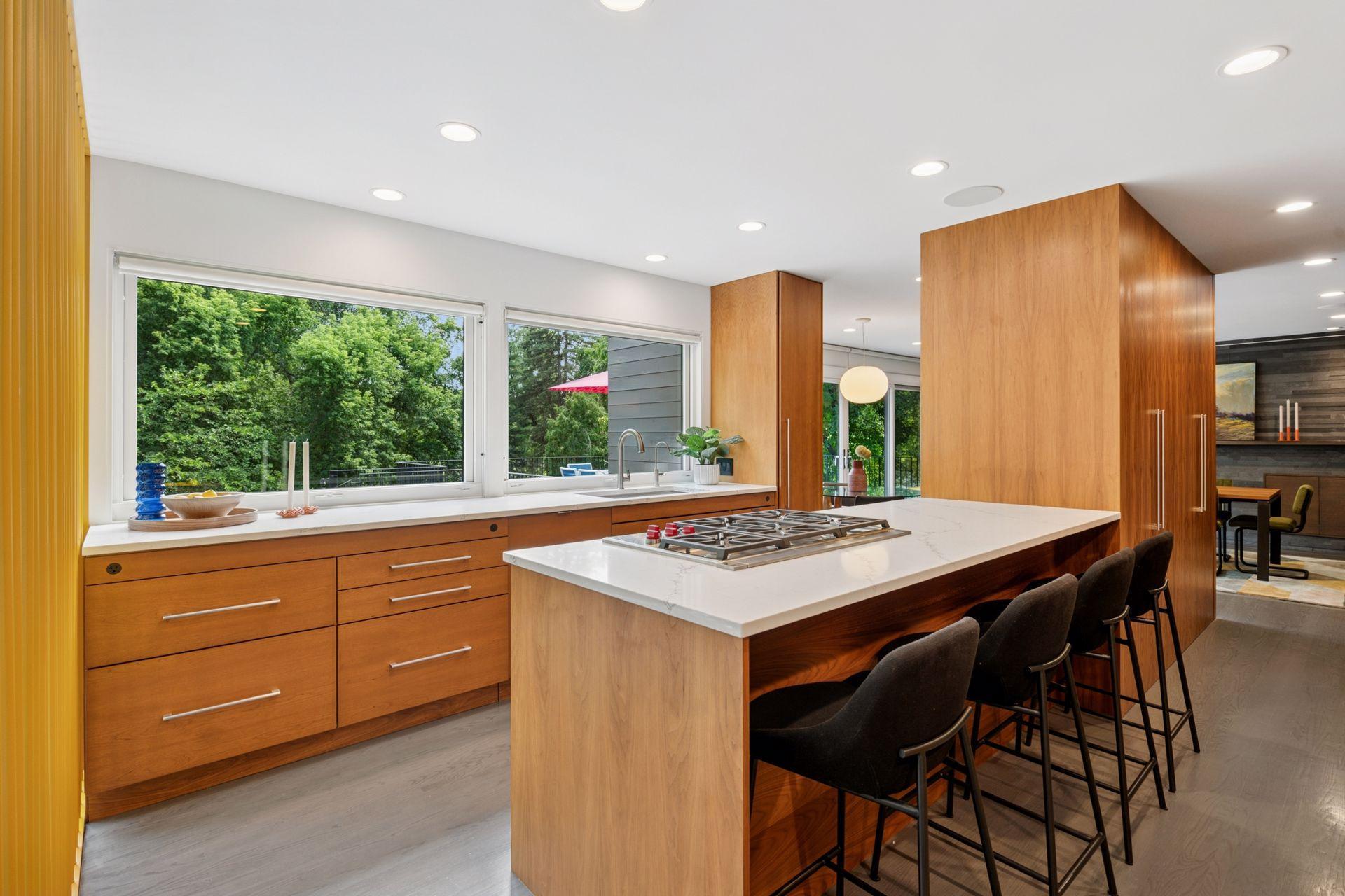 Gorgeous remodeled kitchen with new Wolf Cooktop, quartz countertops, & large glass facing the creek.