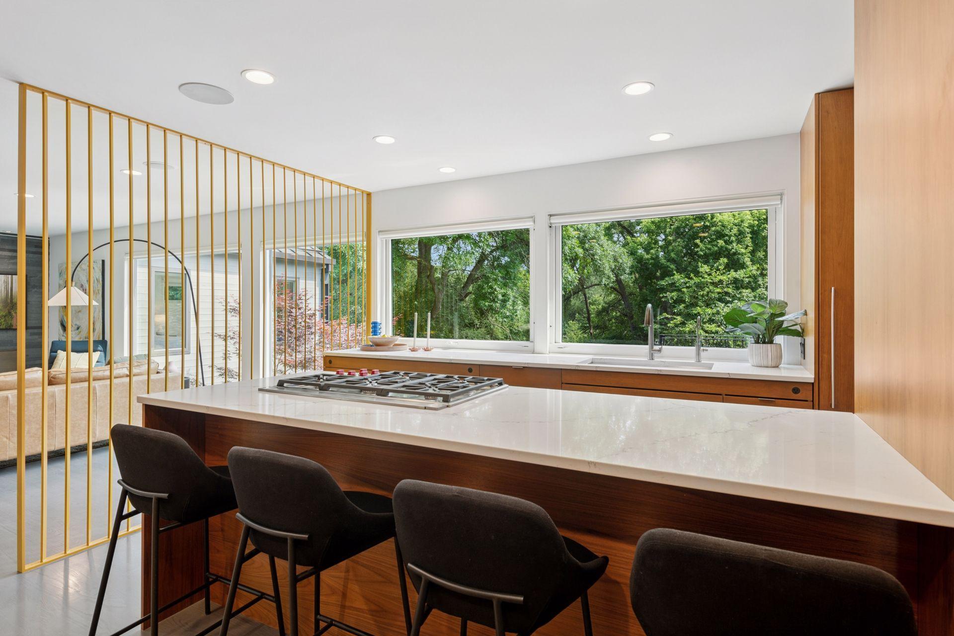 Gorgeous remodeled kitchen with new Wolf Cooktop, quartz countertops, & large glass facing the creek.