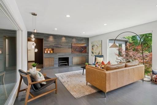 Main level living room with wood burning fireplace and slate tile wall and Frame TV