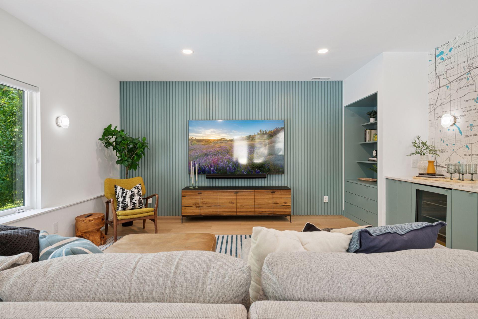 New lower level family room with custom slat wall, storage / display cabinet, and full wet bar