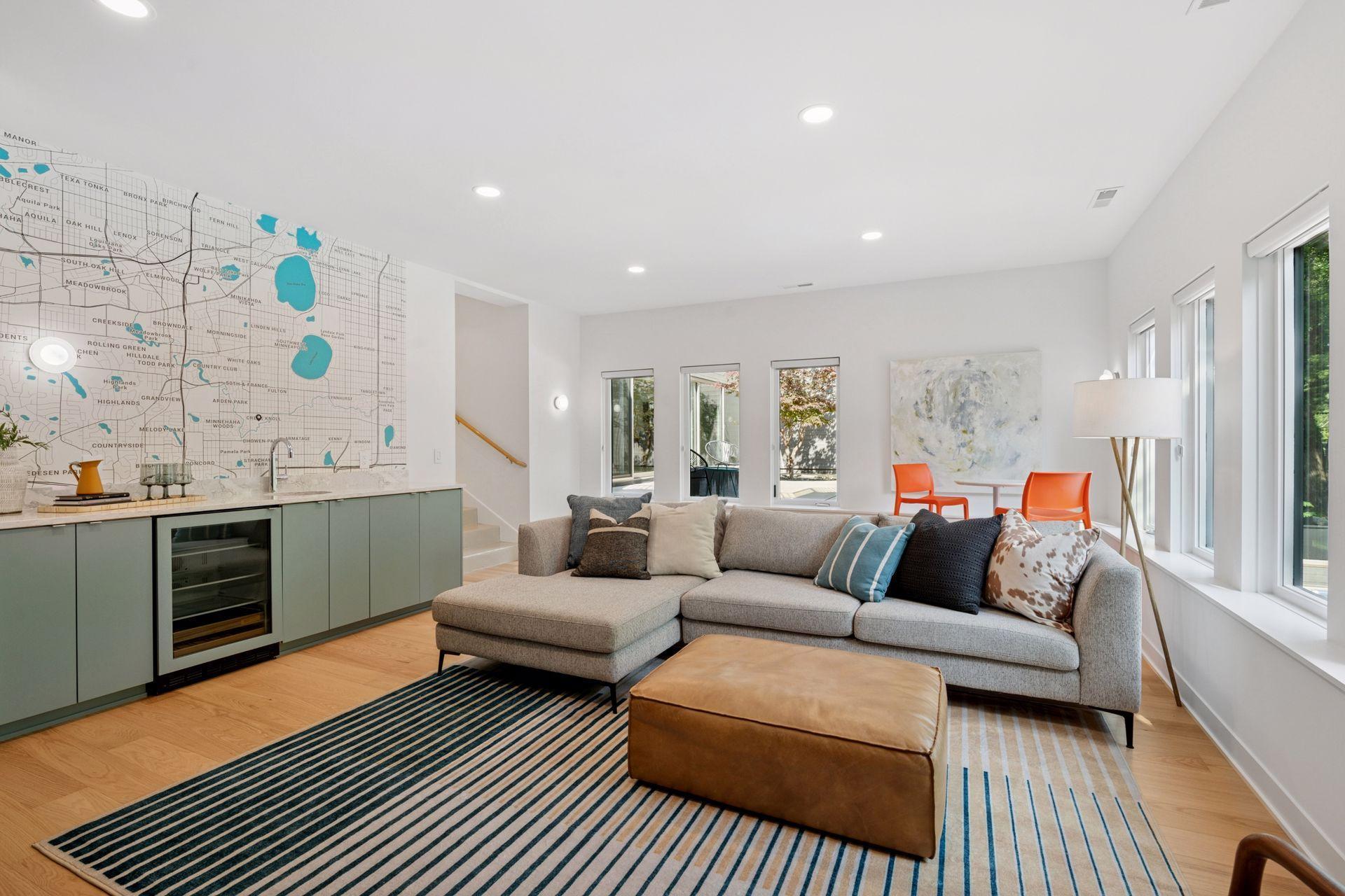 New lower level family room with custom slat wall, storage / display cabinet, full wet bar with beverage fridge, custom wallpaper, and theater surround sound