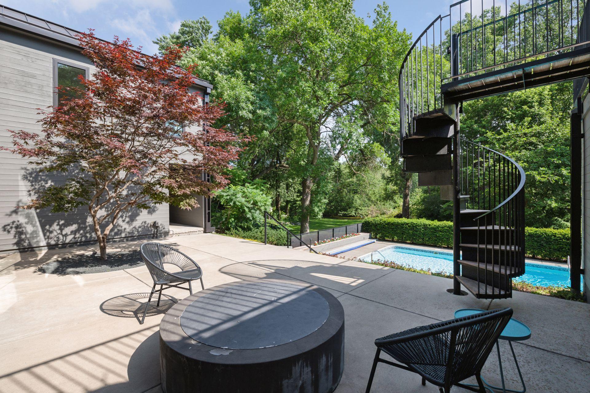 Lower level patio with fire-pit, spiral staircase, and gorgeous ornamental Japanese Maple tree