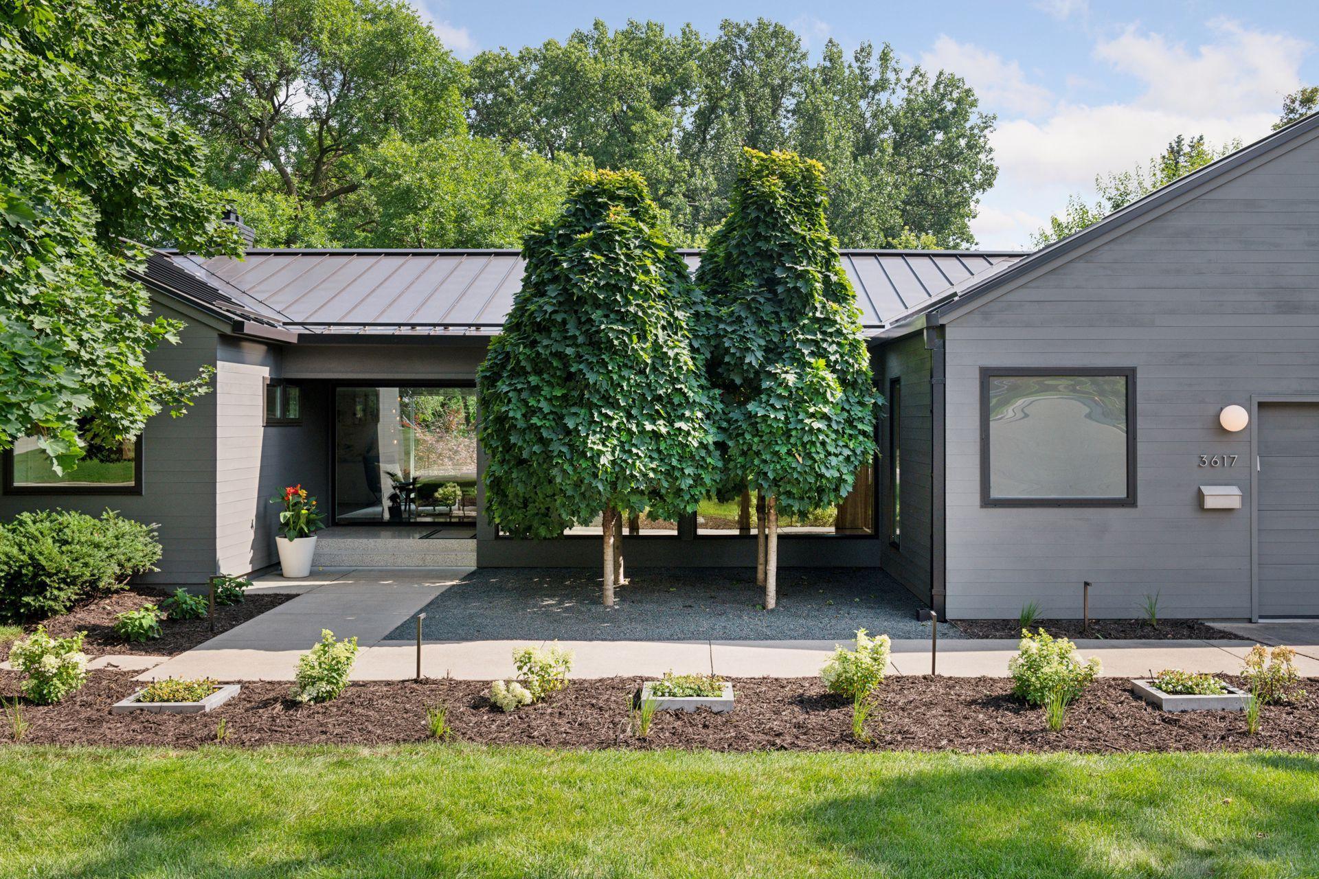 Mid-century modern rambler with a standing seam metal roof & stunning landscaping