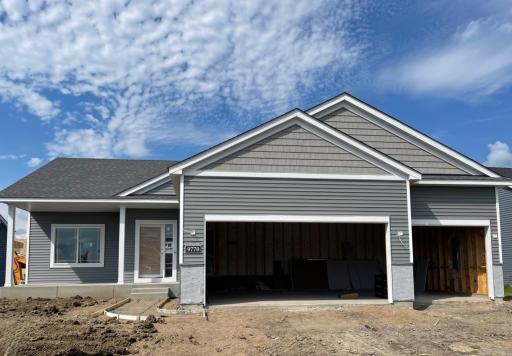 9770 32nd St NE- Photo of home progress taken on 7/11/25. Stone accents will be installed soon. Home features a finished walkout lower level and spacious concrete front porch. Sod, Irrigation System, and Front Plantings included.