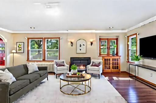 Open, spacious living room has a gas-insert fireplace and built in cabinets under the double windows. Virtually staged