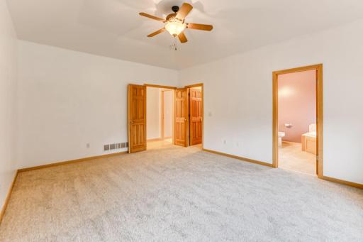 The primary suite is highlighted by elegant six-panel oak French doors, adding warmth and classic style to the space.