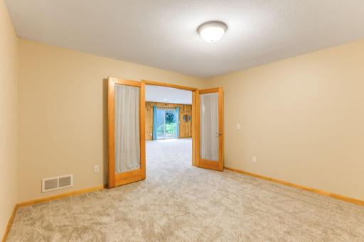 Lower-level office/hobby room features elegant French doors and brand new carpet, creating a quiet and comfortable workspace.